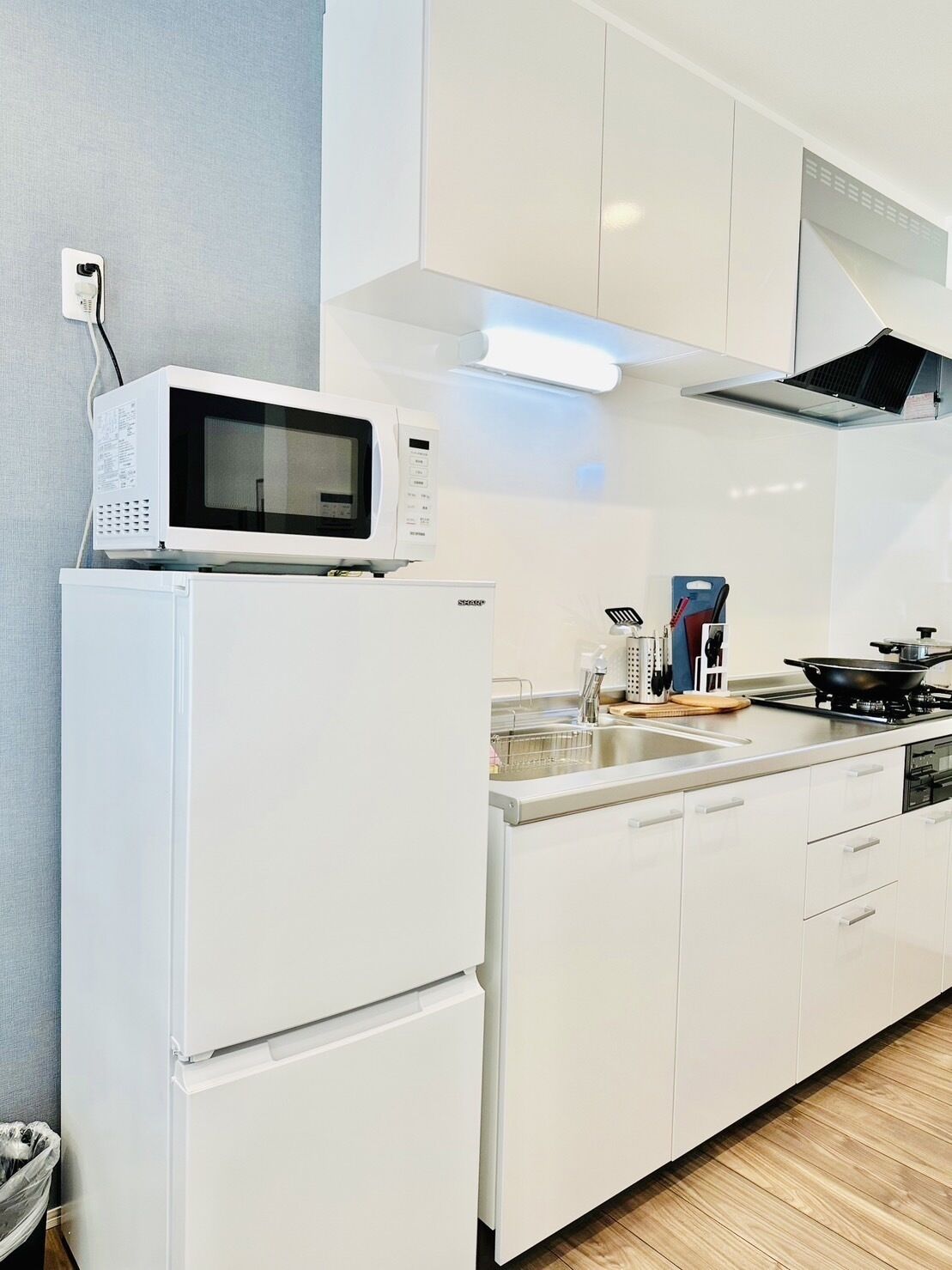 A modern kitchen with white cabinetry, a built-in microwave, and a stove.