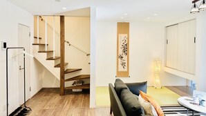 A modern living room with a staircase, a sofa, and a table. - Megu Fuji Plus+ (Fujiyoshida)