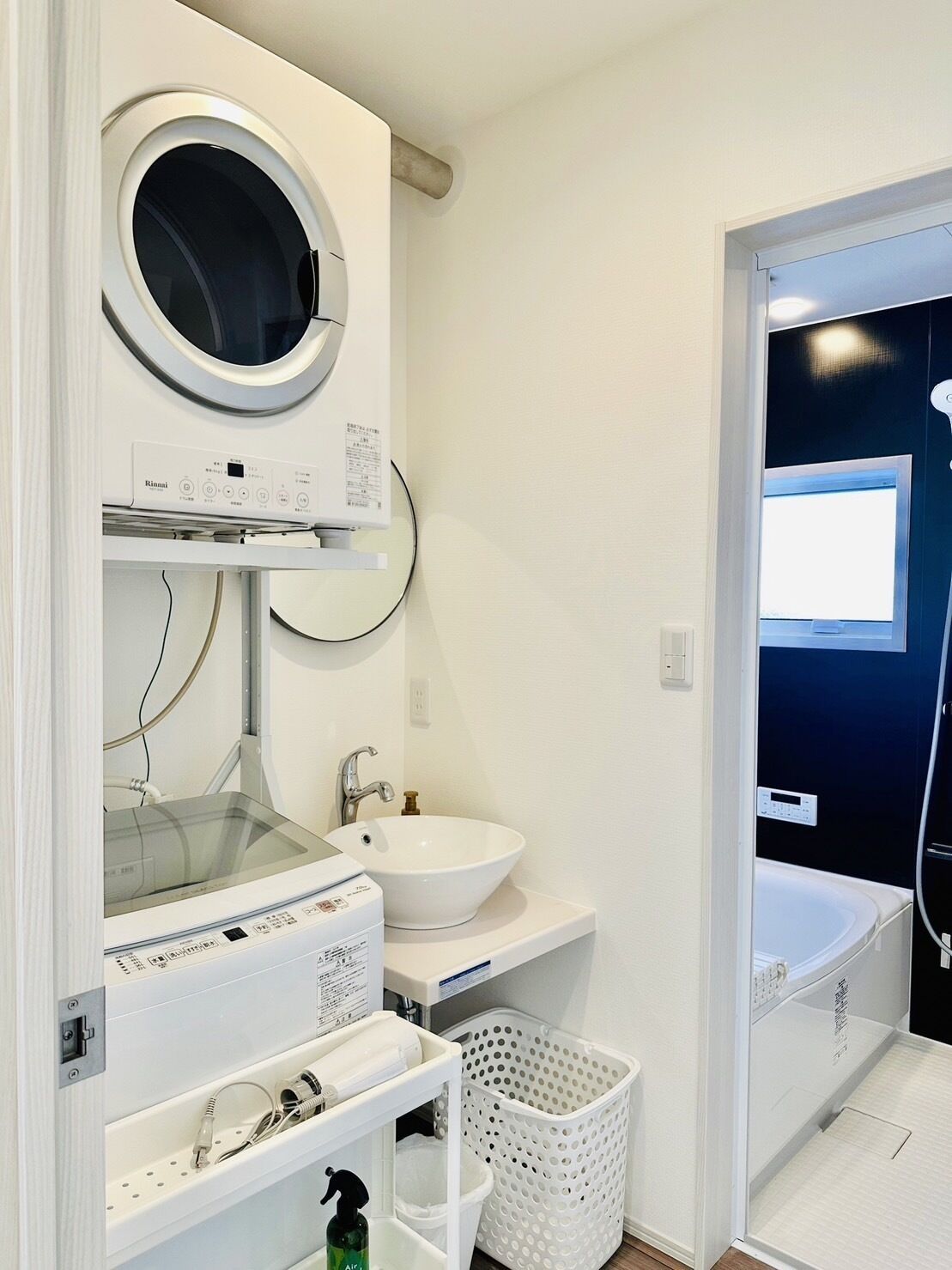 A modern bathroom with a built-in washing machine, a sink, and a bathtub.