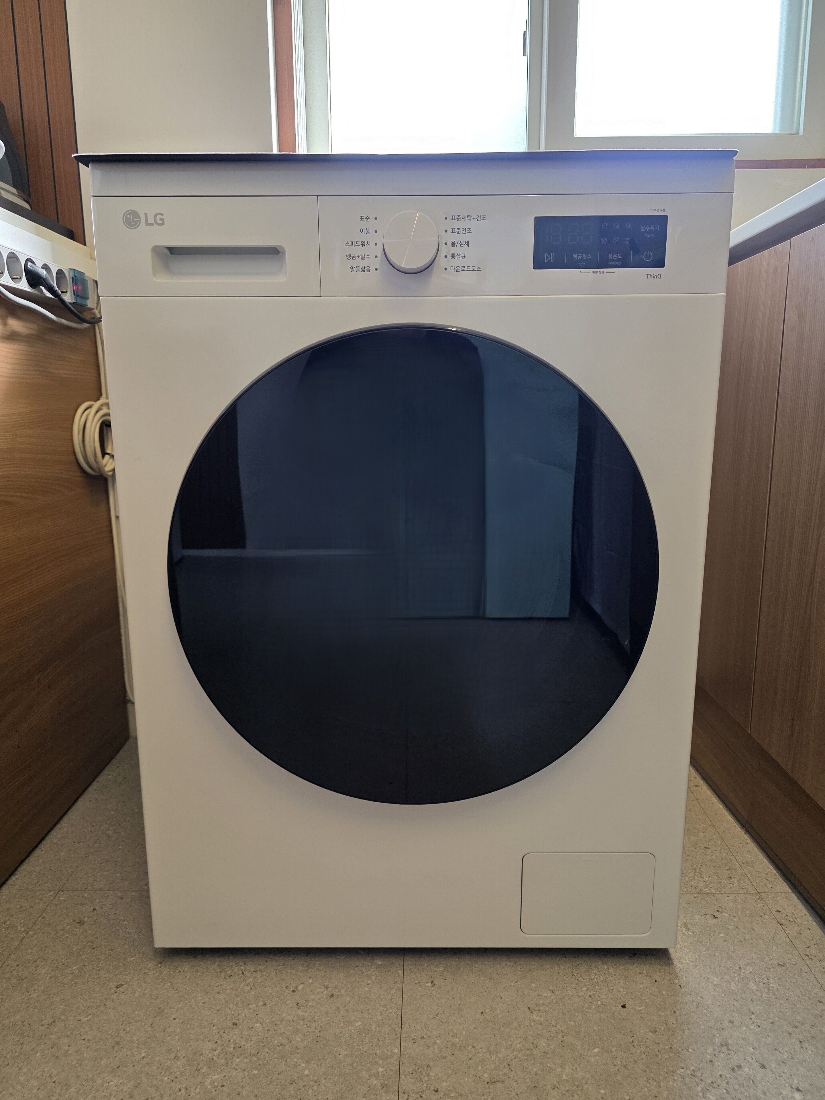 A white LG front-loading washing machine with a control panel and a large circular door.