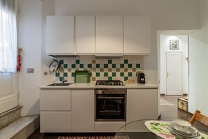 Private kitchen - GuestHost - Apartment located on the ground floor of a 5-storey building. There are steps at the entrance.In 60 m2 of space it accommodates 4 people. Private garden for the exclusive use of guests, table with chairs and ground umbrella.The property is an (Roma)