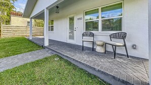 A modern house with a number 1850 on the door, a paved porch, and two chairs. - Gorgeous Downtown Sarasota, Historic Laurel Park Home. (Sarasota)