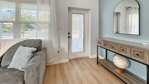 A modern living room with a grey sofa, a wooden console table, and a globe. - Gorgeous Downtown Sarasota, Historic Laurel Park Home. (Sarasota)