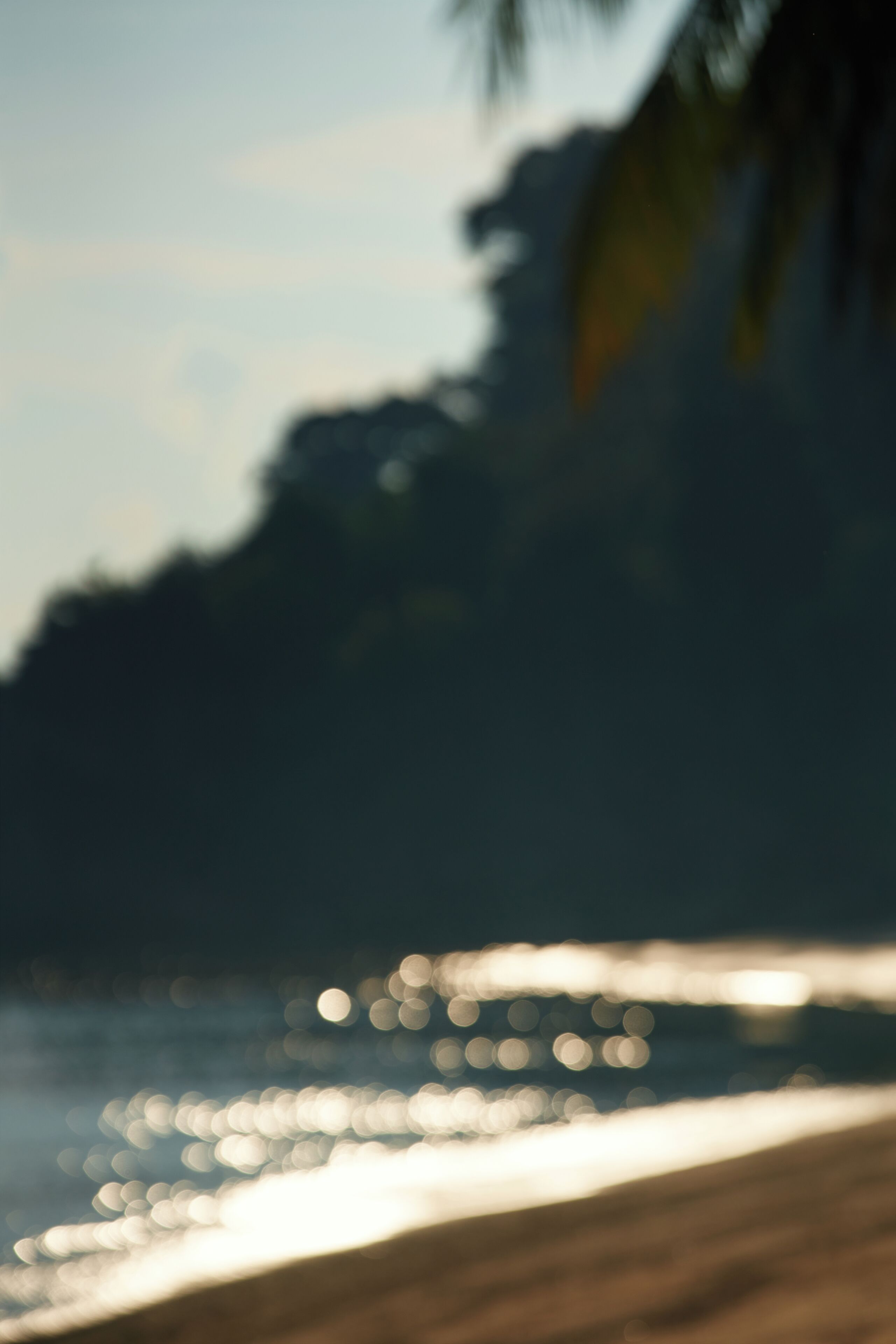 A blurred beach scene with a sandy shore and ocean waves.