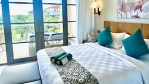 Een hotelkamer met een groot bed, uitzicht op het landschap en een schilderij aan de muur.