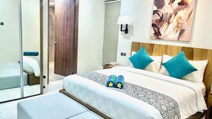 Een hotelkamer met een groot bed, nachtkastje, spiegel en een schilderij aan de muur.