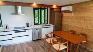 A modern kitchen with white cabinets, stainless steel appliances, and a wooden dining table with chairs.