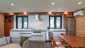 Eine moderne Küche mit Kochinsel, integrierten Geräten und einem Essbereich mit Holzkästen.