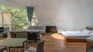 Un hébergement sous tente comprenant un canapé, un lit, une table et des chaises.