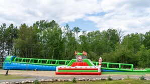A large inflatable water park with slides and a central platform.