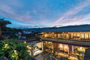 A traditional Japanese building with multiple levels, a courtyard, and a view of the surrounding area. - Liaoshe Garden Hotel (Jianchuan)