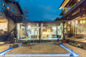 A courtyard with a dining area, potted plants, and a small water feature. - Liaoshe Garden Hotel (Jianchuan)