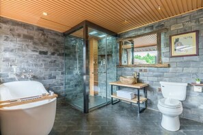 A modern bathroom with a glass shower enclosure, a freestanding bathtub, a toilet, and a wooden vanity. - Liaoshe Garden Hotel (Jianchuan)