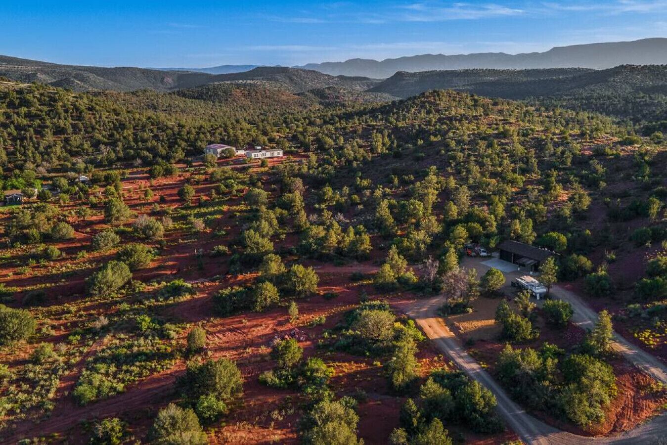 Vista aerea di un paesaggio rurale con edifici sparsi e vegetazione fitta.