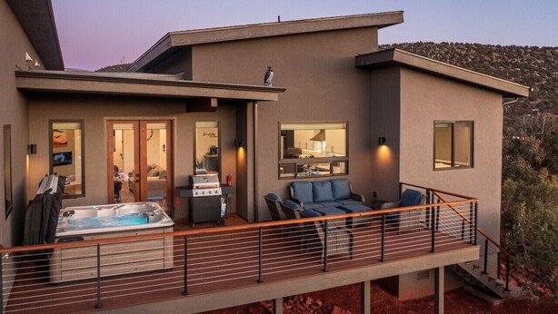 Une maison moderne dotée d’un balcon, d’un jacuzzi et d’un espace barbecue.