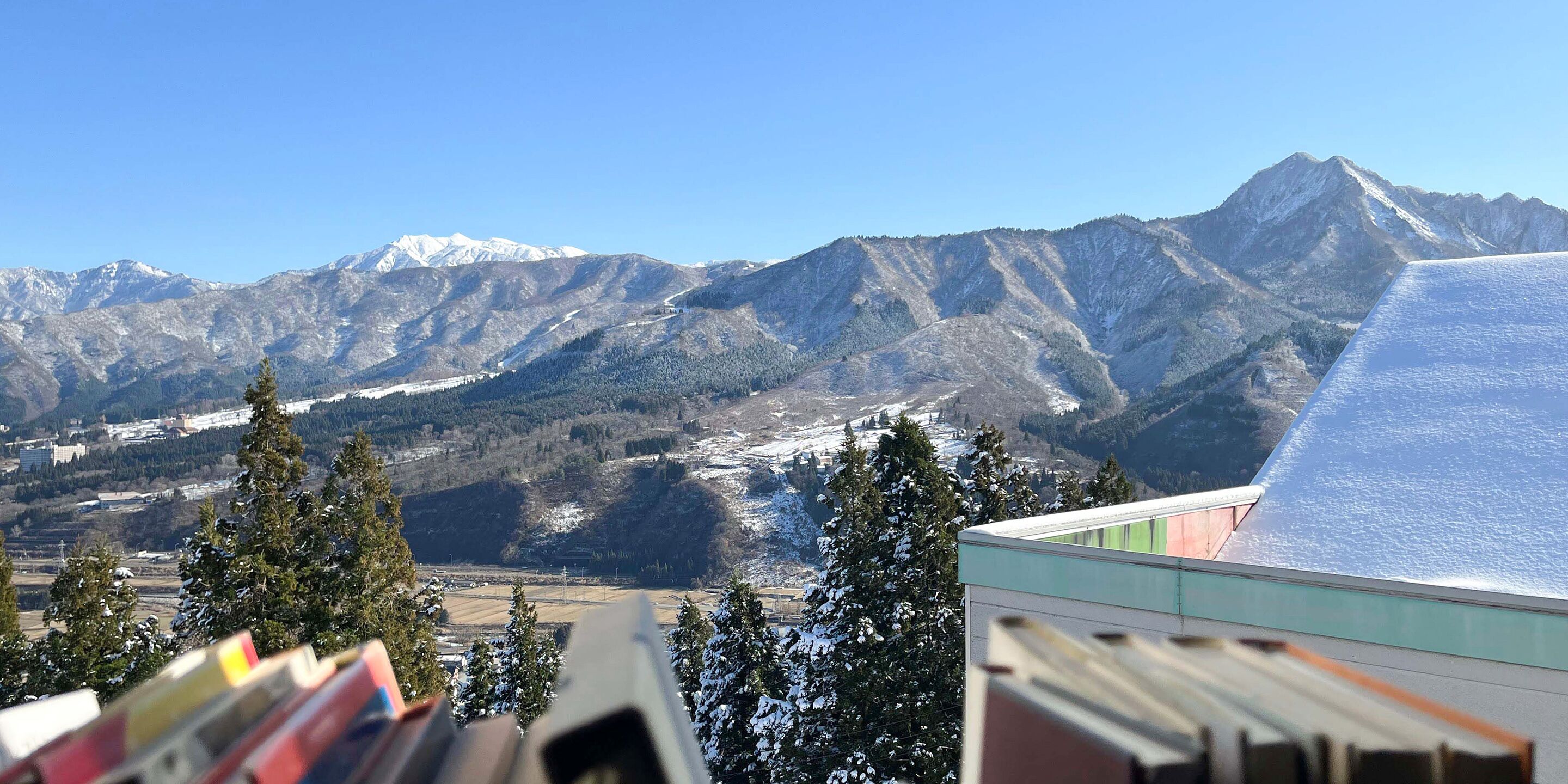 Paesaggio montano con cime innevate e cielo sereno.
