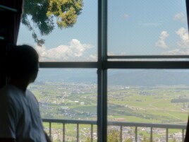 Une vue à travers une fenêtre, avec un ciel dégagé et un paysage lointain.