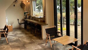 A modern kitchen with a bar area, large windows, and a view of the outdoors. - COUSCOUS Glamping Manazuru (Manazuru)