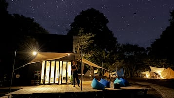 Relax under the stars in a cozy outdoor space with comfortable seating and a sheltered canopy.
