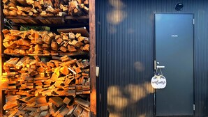 A stack of firewood and a closed door with a 'Staff Only' sign. - COUSCOUS Glamping Manazuru (Manazuru)