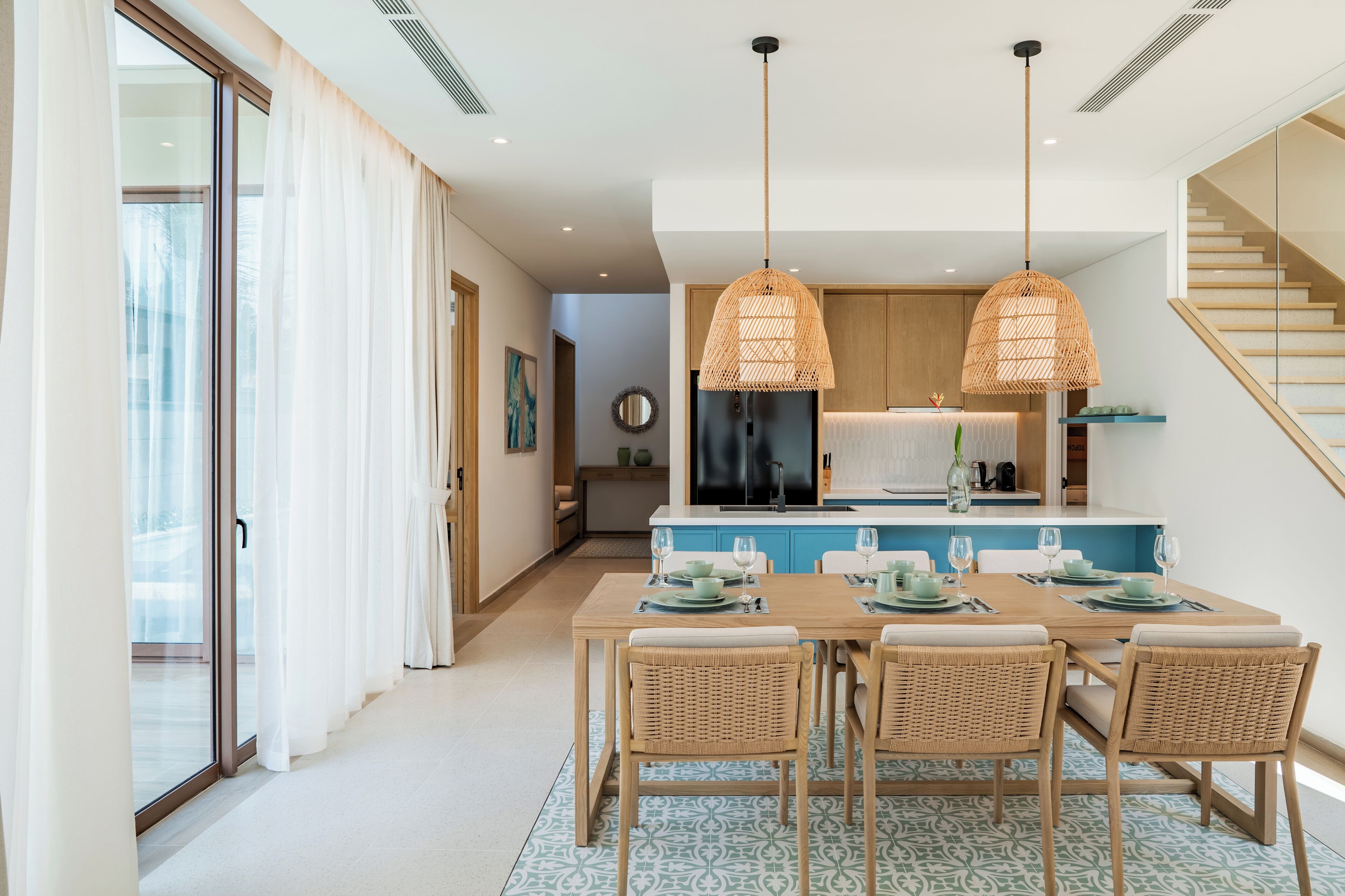 A modern kitchen with a central island, wooden cabinets, and a built-in stove.