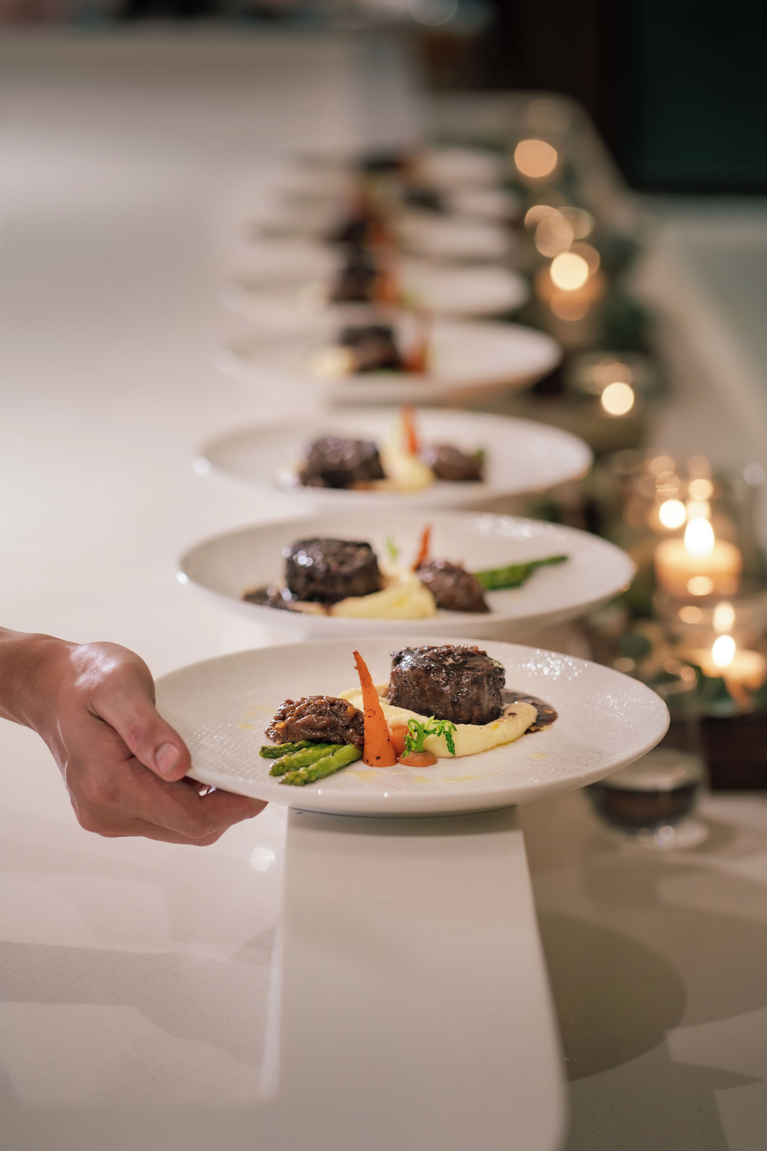 A row of plates with food on a table, likely in a restaurant setting.
