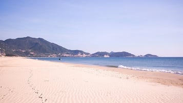 On the beach, white sand, sun-loungers, beach umbrellas