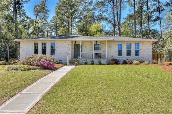 A single-story house with a front porch, a small garden, and a clear sky. - Charming 3 bedroom Masters rental, less than 2 miles from Augusta Nationals! (Augusta)