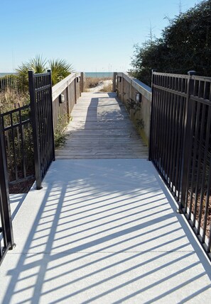 A wooden boardwalk leading to a beach, surrounded by railings and vegetation. - A Place at the Beach II 3B - Oceanfront Complex in Garden City (Garden City)