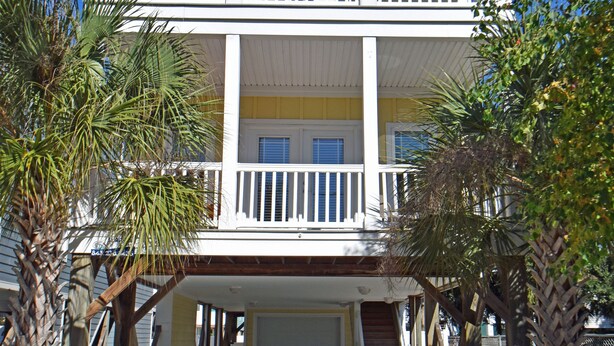 A two-story building with a balcony on the upper floor, a garage at the front, and a pathway leading to the entrance. - Sea For Yourself - 1/2 Block to Ocean in Surfside Beach (Surfside Beach)