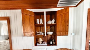 A corner room with two wicker chairs, a white cabinet with decorative items, and a ceiling vent. - Inlet Holiday - Creekfront in Garden City Beach (Garden City Beach)