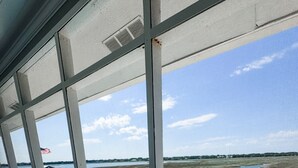 A pool area with a view of a body of water, a dock, and a covered seating area. - Inlet Holiday - Creekfront in Garden City Beach (Garden City Beach)