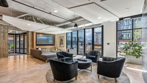 A modern lounge area with comfortable seating, large windows, and a view of the cityscape. - Perfect Dntwn Retreat- Convention Cntr- Amenities! (Salt Lake City)