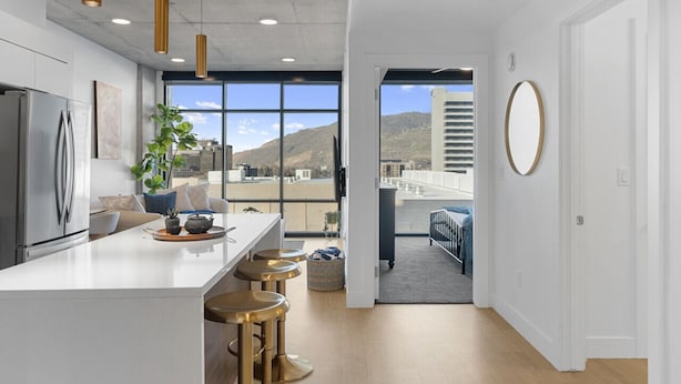 A modern kitchen with a large island, bar stools, and a view of the city. - Perfect Dntwn Retreat- Convention Cntr- Amenities! (Salt Lake City)