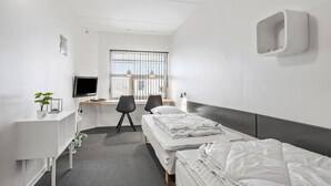 A hotel room with a bed, a desk with a computer, a chair, and a TV. - 2 bedroom stunning apartment in Fanø (Fanø)