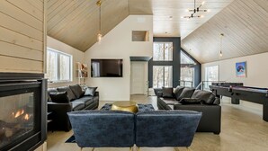 A spacious living area with a fireplace, two sofas, a pool table, and a television. - The Experience SÔ Lodge (SHEFFORD)