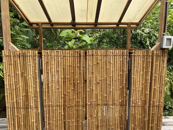 A bamboo fence with a wooden structure above it.
