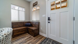A room with a wooden bench, a door with a window, and a patterned rug. - Modern Bungalow in the Heart of Fruita (Fruita)