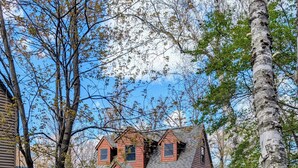 A wooden cabin with a porch, a small staircase, and a grassy yard. - Lake Home property (Luck)