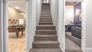 Ein Teppich ausgelegte Treppe führt zu einer Empfangshalle mit einer Tür.