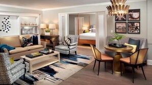Une chambre d’hôtel moderne équipée d’un canapé, d’un fauteuil, d’une table à manger et d’un lit.