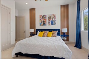 A hotel room with a large bed, two nightstands, a ceiling fan, and artwork on the wall. - Luxury Foothills Estate • Heated Pool, Spa & Views (Tucson)