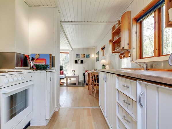 Een koelkast, een microgolfoven, een oven, kookgerei, borden en bestek