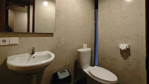 A bathroom with a sink, toilet, and mirror. - Kuta Living (Kuta)