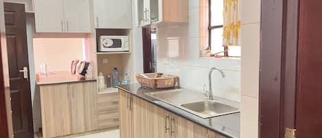 Comfort Apartment | Private kitchen | Fridge, microwave, cookware/dishes/utensils, dining tables