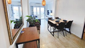 Un comedor moderno con una mesa de madera, sillas negras y un espejo grande.