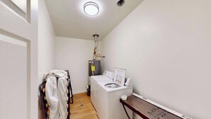 A laundry room with a washing machine, dryer, and a water heater.