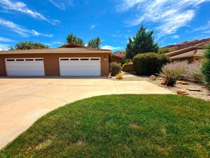 A residential property with a garage, driveway, and landscaped yard. - Portal Vista - 443 (Moab)