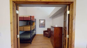 A room with bunk beds, a chair, a dresser, and a framed picture on the wall. - Canyon Portal - 469 (Moab)