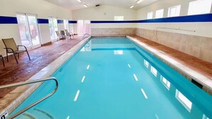 A swimming pool with a 3ft 0in depth marker, surrounded by chairs and a tiled floor.